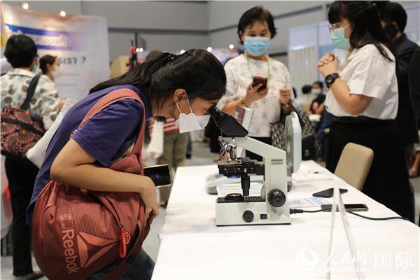 展览会现场，泰国民众体验中医显微镜设备。人民网记者 赵益普摄