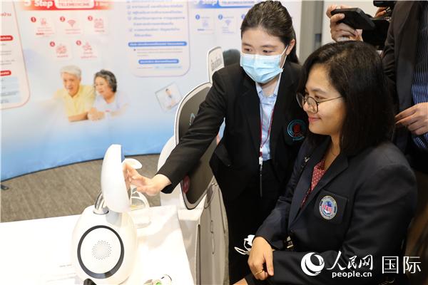 展览会现场，泰国民众体验中医药最新诊断设备。人民网记者 赵益普摄